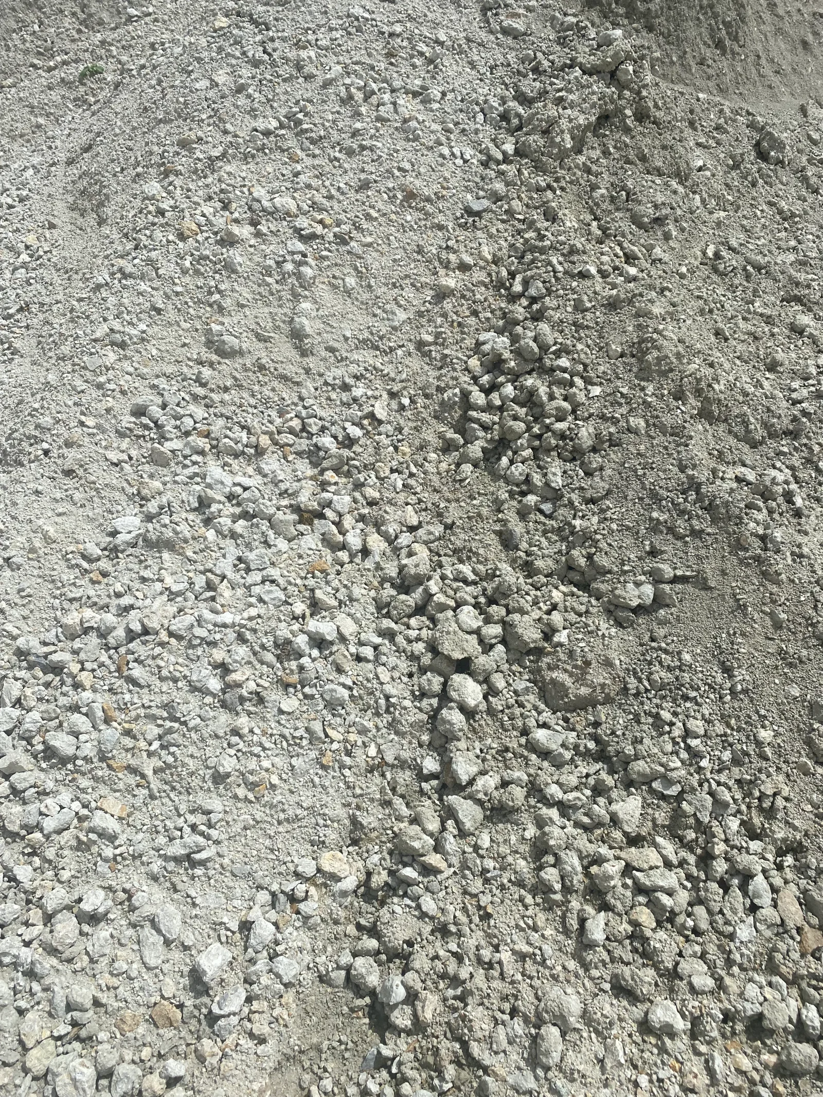 Concrete demolition debris showing crushed concrete aggregate and fine dust material